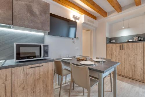 a kitchen with a table with chairs and a microwave at Concilium in Trento
