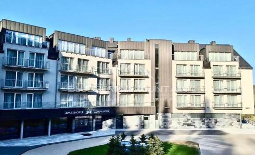 a large apartment building with a parking lot in front of it at Blueberry Mountain Czarna góra in Biała Woda