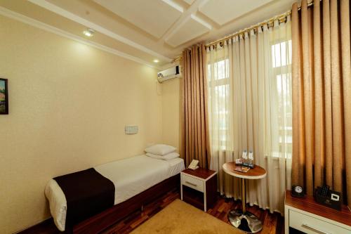 a hotel room with a bed and a window at Asmald Palace Hotel in Kokand