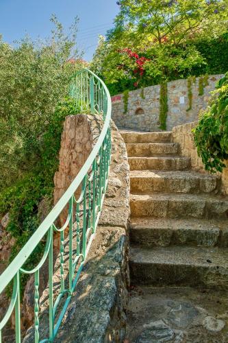 a set of stairs with a green metal railing at Bio Guesthouse Mani Sonnenlink in Pírgos