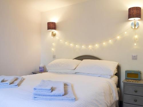 Un dormitorio con una cama blanca con luces. en An Airigh, en Dunan