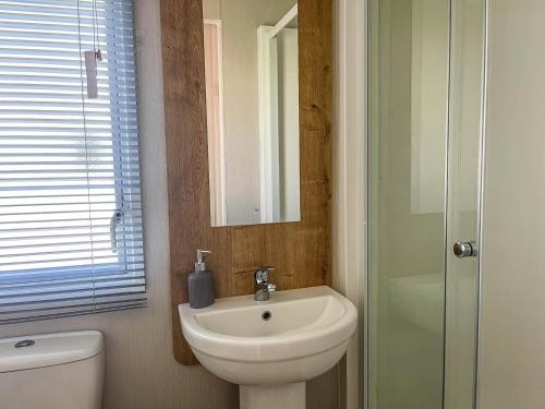 a bathroom with a sink and a toilet and a mirror at Lovely 8 Berth Caravan For Hire At Barmston Beach Holiday Park Ref 62002o in Lund