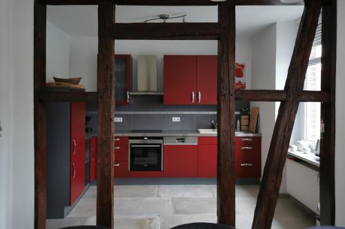La cuisine est équipée de placards rouges et d'un four avec plaques de cuisson. dans l'établissement Mosel Dream, à Cochem