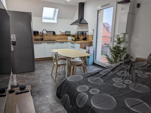 a room with a bed and a table and a kitchen at Au bout de la rue, la MER wifi accès 24 sur 24 IPTV in Sangatte