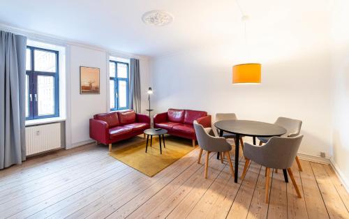 a living room with a table and a red couch at Go Hotel Saga in Copenhagen