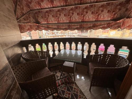 a dining room with a table and chairs and a window at Bab Al Sharia - Lux Apartment in Minyā al Qamḩ