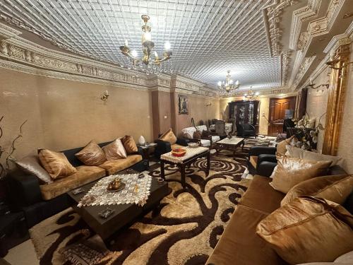 a large living room with couches and a chandelier at Bab Al Sharia - Lux Apartment in Minyā al Qamḩ