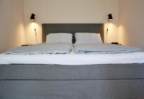 Una cama con dos almohadas blancas encima. en Anna Apartment, en Budaörs