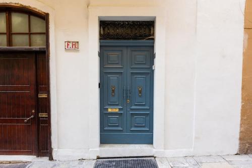una puerta azul en un edificio blanco con una puerta en Valletta Archbishop 2, en La Valeta