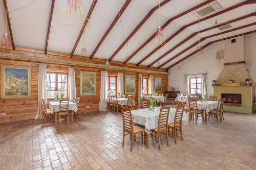 a dining room with tables and chairs and a fireplace at Gospoda Pazibroda in Maków Mazowiecki