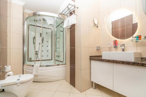 uma casa de banho com um chuveiro, um WC e um lavatório. em Ma City Hotel em Istambul