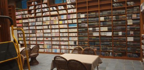 a room with a table in front of a wall of books at Bandal Book & Stay in Sokcho