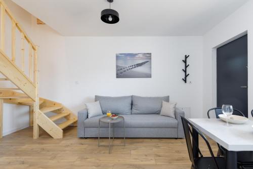 a living room with a couch and a table at Seaside Escape Pet Friendly Apartments Mielenko by Noclegi Renters in Mielenko