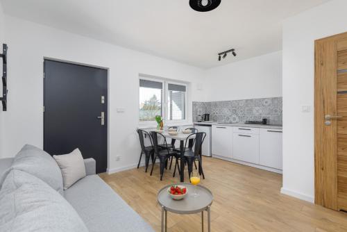 a living room and kitchen with a couch and a table at Seaside Escape Pet Friendly Apartments Mielenko by Noclegi Renters in Mielenko