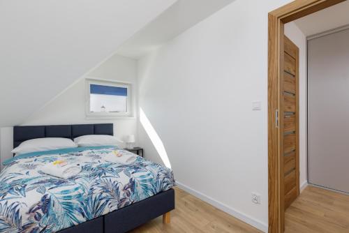a bedroom with a bed next to a staircase at Seaside Escape Pet Friendly Apartments Mielenko by Noclegi Renters in Mielenko