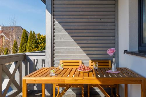 a wooden table with a bowl of fruit on a balcony at Seaside Escape Pet Friendly Apartments Mielenko by Noclegi Renters in Mielenko