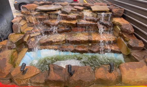 a waterfall in the middle of a rock fountain at Downtowner Inns - Houston Downtown & Convention Center in Houston