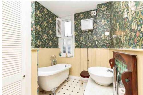 a bathroom with a tub and a toilet and a sink at Garden Apartment.Free parking. Child+dog friendly in Bournemouth