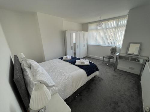 1 dormitorio con cama, escritorio y ventana en M1Link 3 bed house up to 7 people free parking, wifi, M1, transport links, enclosed L garden, en Sutton-in-Ashfield