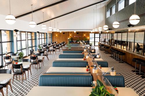 a dining room with tables and chairs and windows at Mollie's Motel & Diner Bristol in Bristol