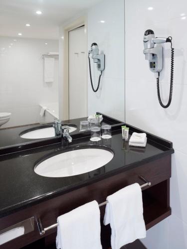 a bathroom with a sink and a mirror at Lindner Hotel Antwerp, part of JdV by Hyatt in Antwerp