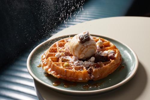 a waffle with ice cream on a plate on a table at Mollie's Motel & Diner Bristol in Bristol