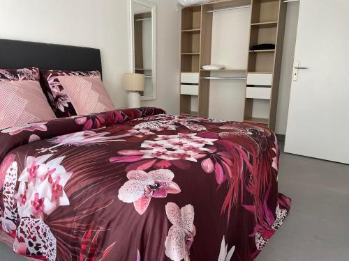 Un dormitorio con una cama con flores rosas. en Chez Mathieu, en Saint-Dizier