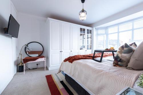 a bedroom with a bed with a table and a mirror at Deepdene Close in Reading