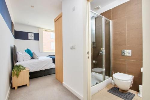 a bathroom with a bed and a shower and a toilet at Swanky city centre apartment in Lincolnshire