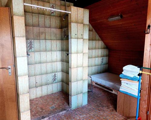 a small shower with a bench in a room at Zimmer im Landhaus in Erkelenz