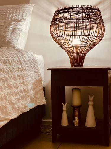 a lamp on a table next to a bed at Idesel Apartment in Edendale