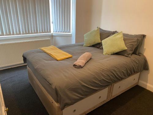 a bed with two pillows and a towel on it at Coventry Spacious House in Coventry