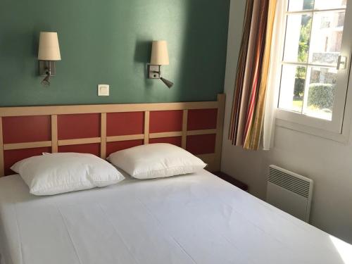 - une chambre avec un lit avec deux oreillers et une fenêtre dans l'établissement Appartement 3 pièces avec grande terrasse, climatisation, piscine et parking - FR-1-504-659, à Saint-Raphaël
