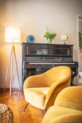 a living room with a chair and a piano at Villa Arizona in Milano Marittima