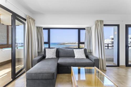 a living room with a couch and a view of the ocean at Apartamentos Arrecife Playa in Arrecife