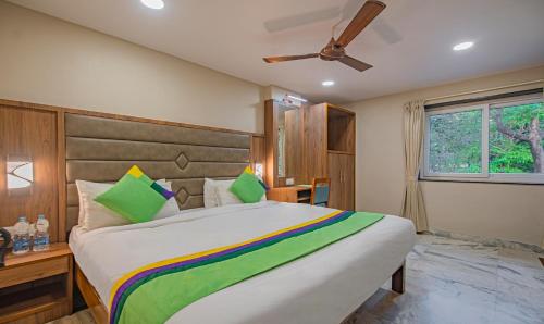 a bedroom with a large bed and a window at Treebo Gyani's in Jamshedpur