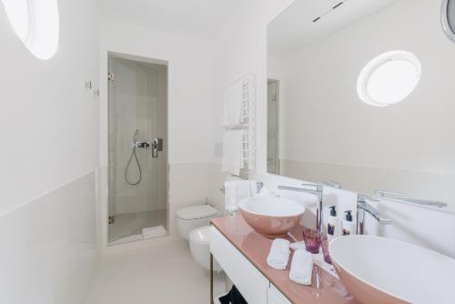 a white bathroom with two sinks and a shower at Palazzo M Capri in Capri