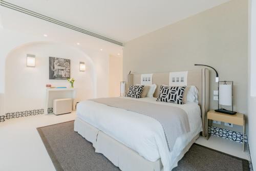 a white bedroom with a large white bed with pillows at Palazzo M Capri in Capri