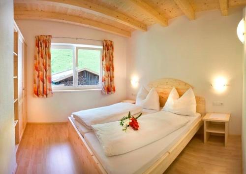 een slaapkamer met een bed met een bloem erop bij Wildauhof in Fügenberg