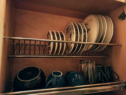 a shelf with plates and cups on it at Beehouse Arví Cabaña in Guarne