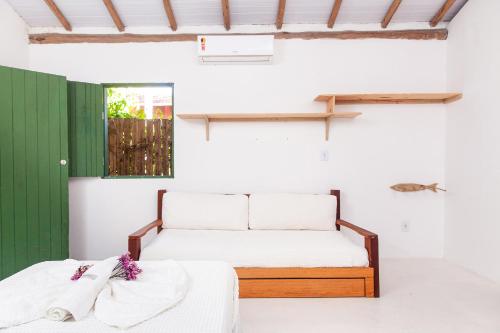 zwei Betten in einem Zimmer mit einer grünen Tür in der Unterkunft Vila Nativa Caraíva in Caraíva