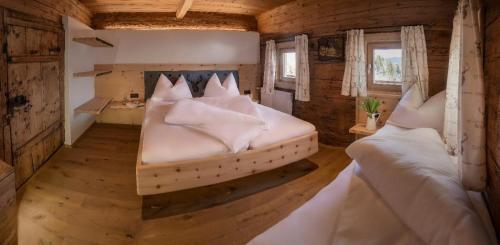 a bedroom with two beds in a wooden cabin at Wildauhof - Alm in Fügenberg