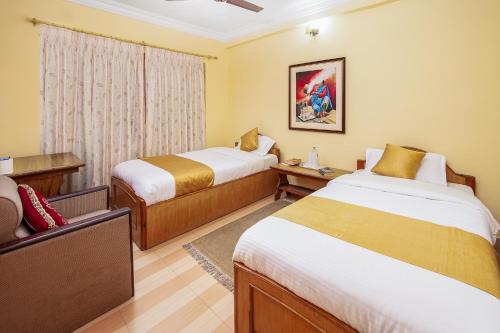 a hotel room with two beds and a window at Hotel Yeti in Pokhara
