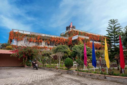 a building covered in flowers with flags in front of it at Hotel Yeti in Pokhara