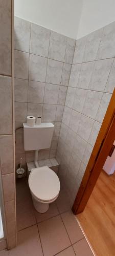 a bathroom with a white toilet in a room at Szabó József Evangélikus Vendégház in Balassagyarmat
