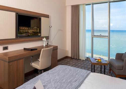 a hotel room with a bed and a desk with a computer at Ramada Plaza by Wyndham Rize in Rize