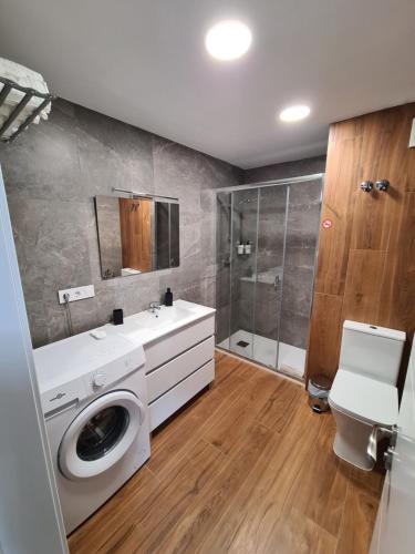 y baño con lavadora y ducha. en Hlius Brand New Apartments en Valencia