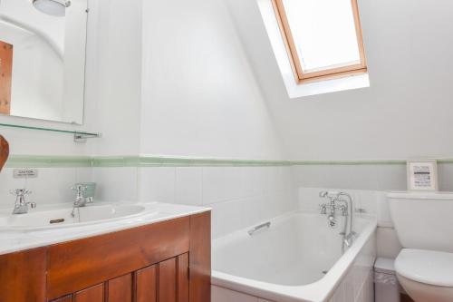 a bathroom with a tub and a sink and a toilet at Tithe Barn a Stunning family home with panoramic views in Ryde