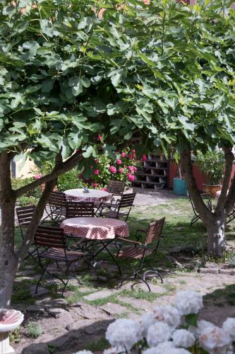 a picnic table and chairs under a tree at Hotel Klostergaarden in Allinge