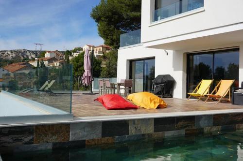 two colorful pillows are sitting next to a swimming pool at ® L'imprenable - Somptueuse villa vue mer in Marseille